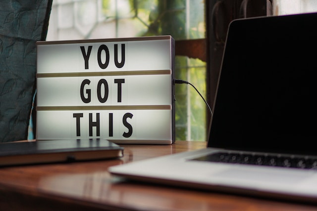 A sign saying ‘You got this’ next to a laptop